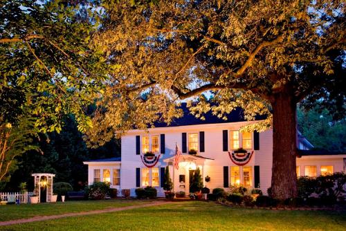 a white house with a tree in front of it at A Williamsburg White House Inn in Williamsburg