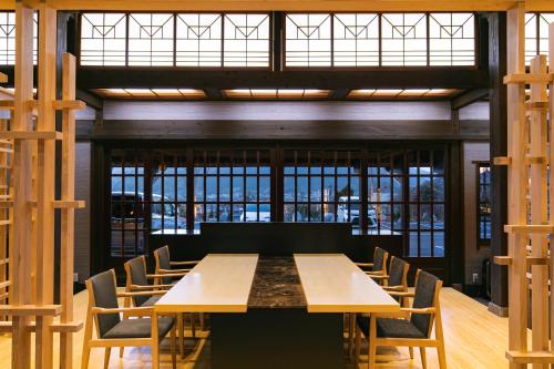 a conference room with a wooden table and chairs at Baien in Yufuin