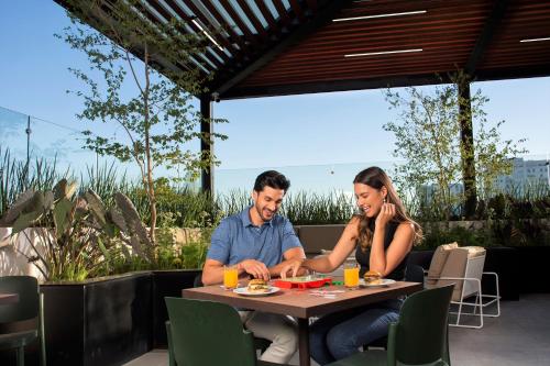 a man and a woman sitting at a table at Staybridge Suites - Guadalajara Novena by IHG in Guadalajara