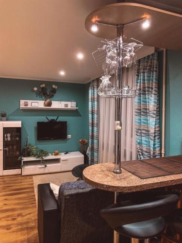 ein Wohnzimmer mit einem Tisch und ein Wohnzimmer mit blauen Wänden in der Unterkunft Apartment in Daugavpils Centre in Daugavpils