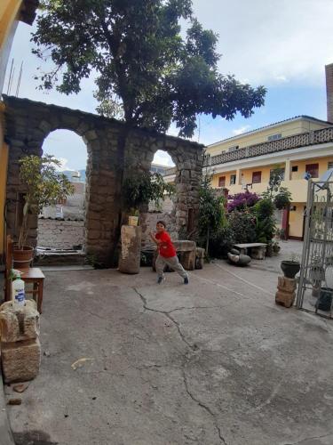 a man throwing a frisbee in front of a building at HOSPEDAJE CENTRAL in Ayacucho