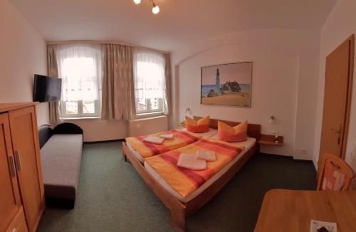 フライベルクにあるGästehaus Heidiのベッドルーム1室(大型ベッド1台、オレンジ色の枕付)