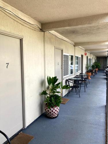 a corridor of a building with tables and chairs at Cairns City Motel in Cairns