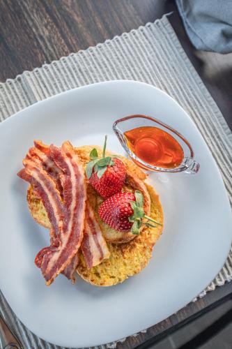 a plate of breakfast food with bacon and strawberries at Little Kubu Lodge in Hoedspruit