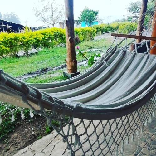 a hammock sitting on the ground next to a tree at Cabañas Guacari San Agustín huila in San Agustín