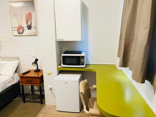 a small room with a microwave on a counter at Millers Cottage Motel in Wangaratta