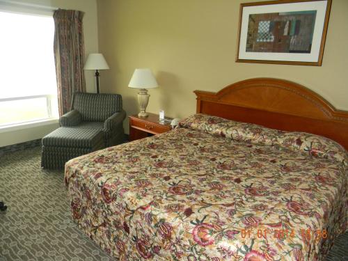 a hotel room with a bed and a chair at Lakeview Inn Centralia in Centralia