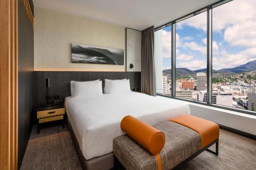 a hotel room with a bed and a large window at Mövenpick Hotel Hobart in Hobart