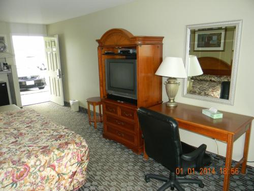 Habitación de hotel con escritorio, cama y TV en Lakeview Inn Centralia, en Centralia