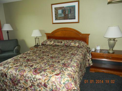 a hotel room with a bed and a chair at Lakeview Inn Centralia in Centralia