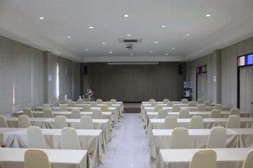 an empty room with white tables and chairs at Oon Valley Farm Stay in Ban Mae Pha Haen