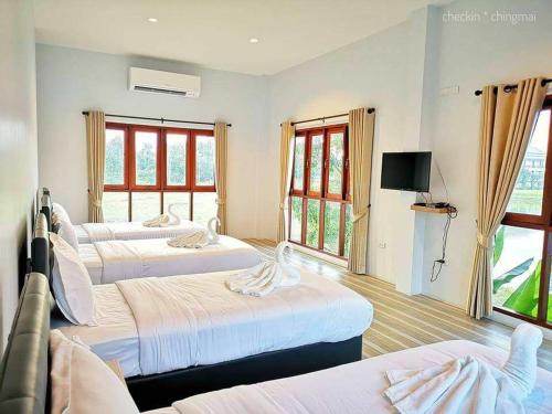 a hotel room with four beds and a television at Oon Valley Farm Stay in Ban Mae Pha Haen