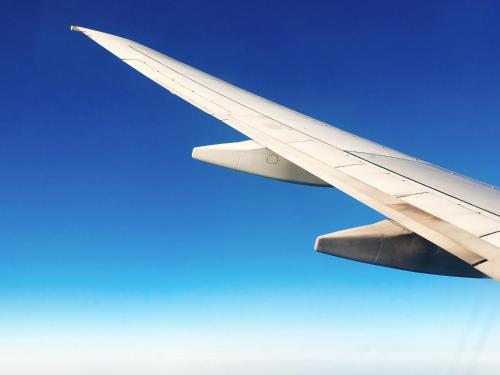 a wing of an airplane flying in the sky at Hotel Code Shinsaibashi in Osaka