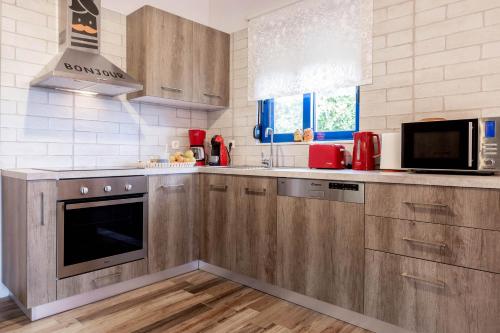 a kitchen with wooden cabinets and a stove top oven at Villa Dimitrios in Kiotari