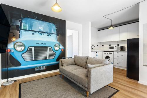 a living room with a couch and a painting of a truck at SoYa on Davis Apartment Hotel in Melbourne
