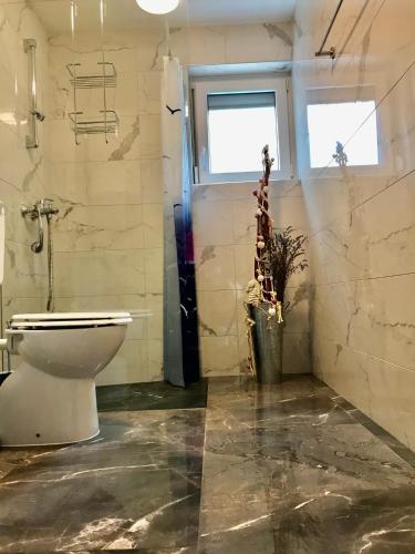 a bathroom with a toilet and a window at Apartment Tušek in Jadranovo