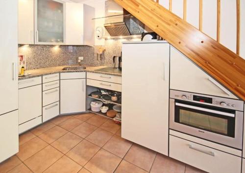 a kitchen with white cabinets and a staircase at Residenz-Ostseestrand-Wohnung-30-337 in Kühlungsborn