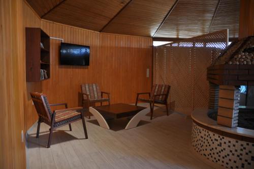 a room with chairs and a table and a tv at Arcadia Hotel in Cıralı