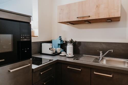 a kitchen with a sink and a stove top oven at Alpenwolke Appartements in Kempten