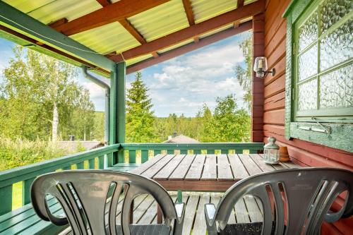 eine Veranda mit 2 Stühlen und einem Holztisch in der Unterkunft Ekesberget Stugby Stuga 8 in Ekshärad