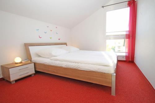 キュールングスボルンにあるBuesumer-Ring-Strandmuschel-501のベッドルーム1室(ベッド1台付)、赤いカーペットの窓が備わります。