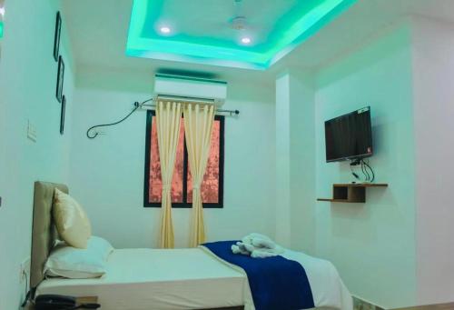 a hospital room with a bed and a flat screen tv at Zcube Andaman in Port Blair