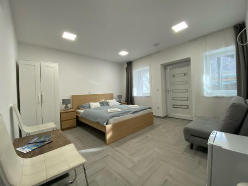 a bedroom with a bed and a desk and a chair at Sulyom Panzió in Tiszafüred