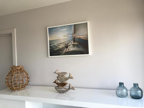 a shelf with a picture of a boat on the wall at Whaaw Oostende in Ostend