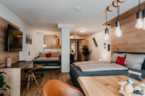 Alpenwolke Appartements في كمبتن: غرفة نوم مع سرير وغرفة معيشة