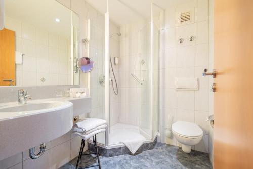 a bathroom with a shower and a sink and a toilet at Hotel-Gasthaus Adler in Schopfheim
