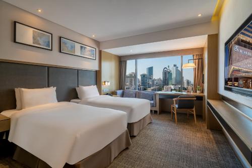 two beds in a hotel room with a view at Zenith Hotel-Near Train Station & The Mixc in Xiamen