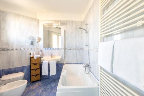 ein Badezimmer mit einer weißen Badewanne und einem Waschbecken in der Unterkunft Hotel Baia Imperiale in Rimini