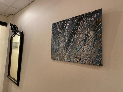 a painting hanging on a wall next to a mirror at L'Escale des Alpilles in Rognonas