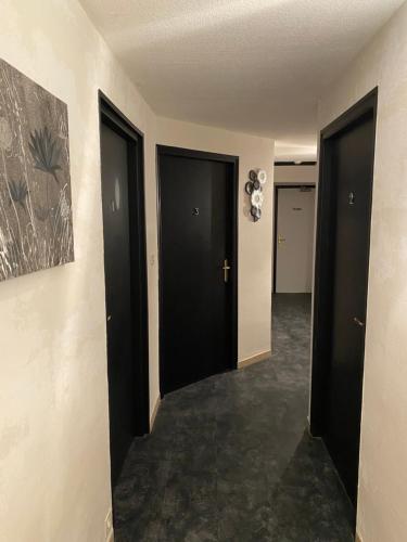 a hallway with two black doors in a room at L'Escale des Alpilles in Rognonas