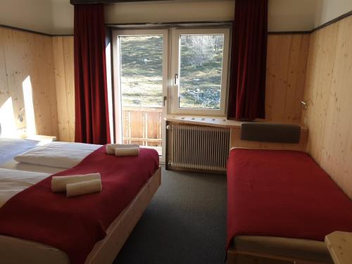 a hotel room with two beds and a window at Berghotel Türlwand in Ramsau am Dachstein