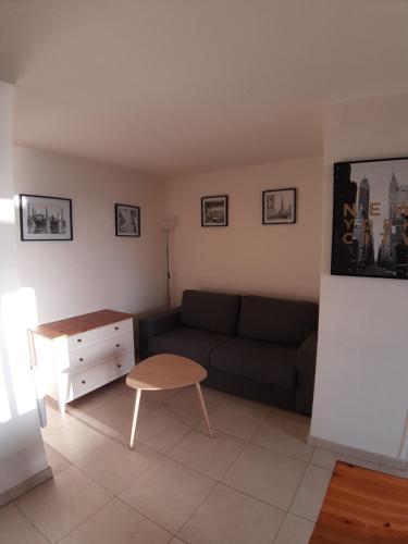 sala de estar con sofá y mesa en appartement Cavalaire face à la mer en Cavalaire-sur-Mer
