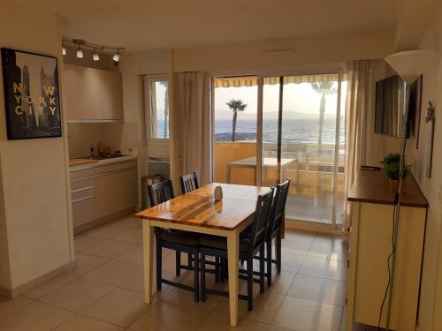 een keuken en eetkamer met een tafel en stoelen bij appartement Cavalaire face à la mer in Cavalaire-sur-Mer