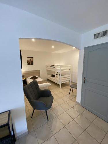 a living room with a chair and a bed at Logis Hôtel L'Oliveraie in Cognac