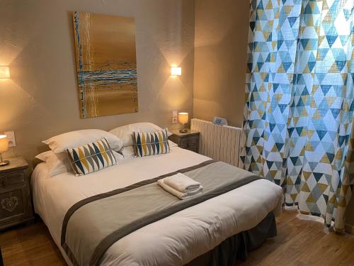 a bedroom with a large bed with two pillows at L'Escale des Alpilles in Rognonas