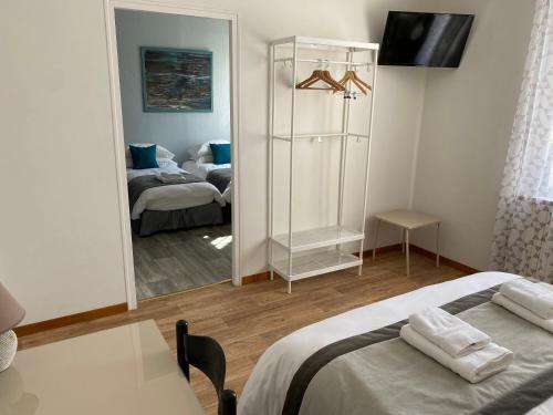 a bedroom with a bed and a mirror with a couch at L'Escale des Alpilles in Rognonas