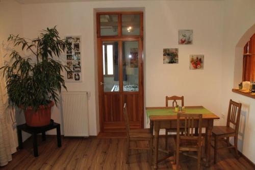 un comedor con mesa, sillas y una planta en Ferienvilla-Teisendorf OG, en Teisendorf