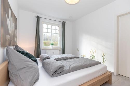 キュールングスボルンにあるHaus-Ostseewelle-Wohnung-3-9527の窓付きの白い部屋のベッド1台