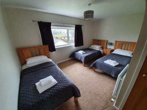 um quarto com 2 camas individuais e uma janela em Elder howe em Penrith