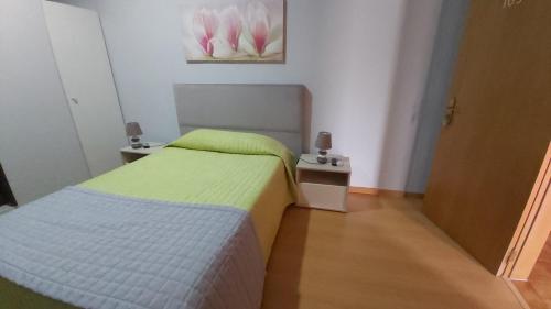 a small bedroom with a bed and two night stands at Residencial as Canárias in Ponte de Sor