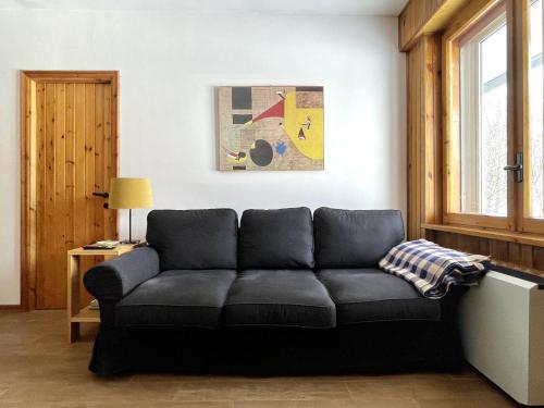 a black couch in a living room with a window at Appartamento Dimora della Volpe - Terminillo in Terminillo