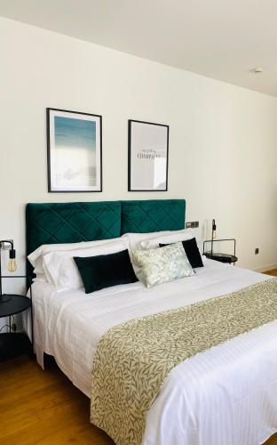 a bedroom with a large bed with a green headboard at Hotel Carbonell in Llança