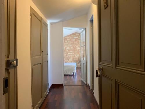 un couloir vide avec une porte ouverte et une chambre dans l'établissement Bastide Sainte Agnès, à Carpentras