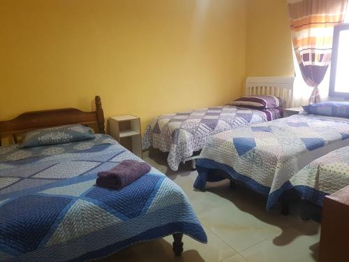 1 Schlafzimmer mit 3 Betten in einem Zimmer in der Unterkunft Anexo Golden in Cochabamba