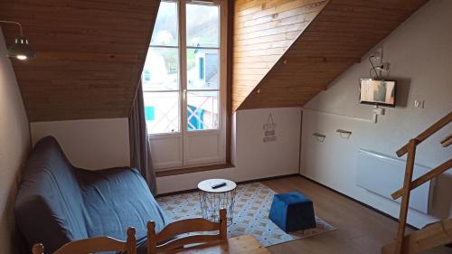 Cette chambre mansardée dispose d'un escalier et d'une fenêtre. dans l'établissement Appartement Sainte Marie de Campan - Résidence le Vieux Village, à Sainte-Marie-de-Campan