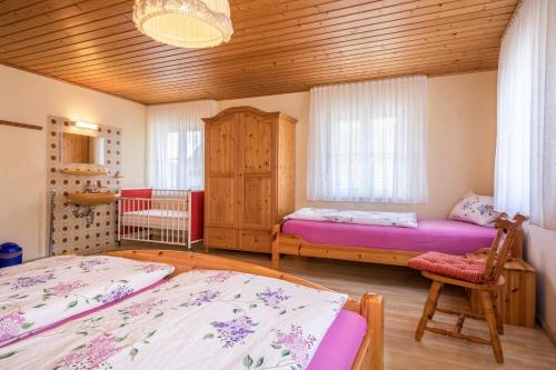 a bedroom with two beds and a wooden ceiling at Zapfs Bauernhof Pfingstrose in Tettnang